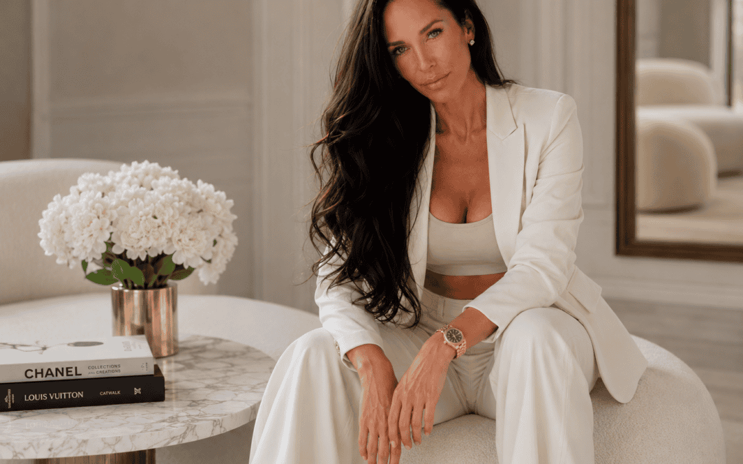 Elegant woman in white suit sitting on a sofa in a luxurious room.