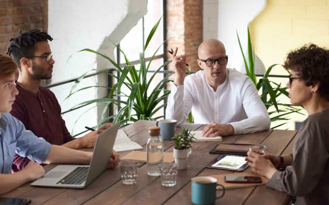Business meeting with diverse team discussing strategies at a wooden table.